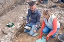 Volunteers excavating painted wall plaster