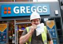 A customer outside a branch of Greggs