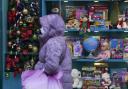 A shopper wearing face mask passes a festive shop display. Photo: PA.