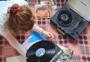 Photo of a music lover listening to a record player. Photo via Natasha Meek/Newsquest.