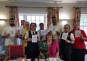 Judith Forster, seated, with some of the 73 Abbey View staff members who she sketched. From left: Mannie, Elisa, Tracey, Simmi, Thushara, George, Bobbi and Sara.