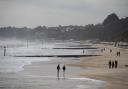 People walk along Bournemouth beach in Dorset as the cold snap continues to grip much of the