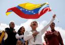 Opposition leader Maria Corina Machado waves a Venezuelan national flag (AP)