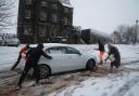 People help a driver in the snow in Stirling, Scotland, during Storm Bert (Andrew Milligan/PA)