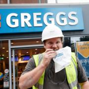 A customer outside a branch of Greggs