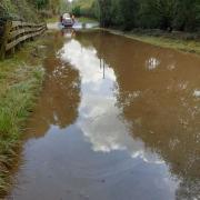 Police have closed Furzebrook Road, on the way to The Blue Pool Nature Reserve and Tearooms, after car attempt to drive through the water and got stranded. Photo from Purbeck Police