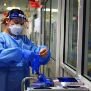 A nurse puts on PPE in a ward for Covid patients at King's College Hospital, in south east London.  Picture: PA