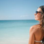 A woman standing in front of the sea. Credit: Canva