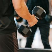 A man exercising with dumbbells. Credit: Canva