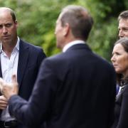 The Prince of Wales (left) chats with members of council and community groups during a visit to Faithworks Carpentry Workshop