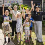 Colehill Community Library Chair of Trustees Susan Cowsill with Sherry Newton from Omaze and some keen young readers presenting Omaze’s donation of £25,000