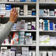 A pharmacist stocking shelves at a chemist