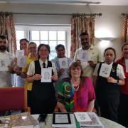 Judith Forster, seated, with some of the 73 Abbey View staff members who she sketched. From left: Mannie, Elisa, Tracey, Simmi, Thushara, George, Bobbi and Sara.