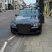 BMW parked on white zig zag lines