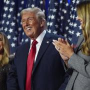 Republican presidential nominee former President Donald Trump stands on stage with former first lady Melania Trump, as Lara Trump watches, at an election night watch party at the Palm Beach Convention Center, Wednesday, Nov. 6, 2024, in West Palm Beach,