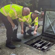 Environment officers inspecting the wet well at a pumping station to make sure all pumps, chains and floats are in good working order