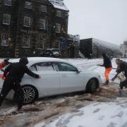 People help a driver in the snow in Stirling, Scotland, during Storm Bert (Andrew Milligan/PA)