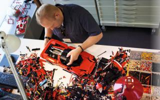 A man assembling LEGO's new Technic Ferrari Daytona SP3. Credit: LEGO