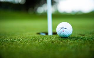 A golf ball by the hole. Credit: Canva