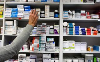 A pharmacist stocking shelves at a chemist