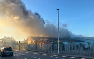 Smoke plumes into sky after derelict building catches fire