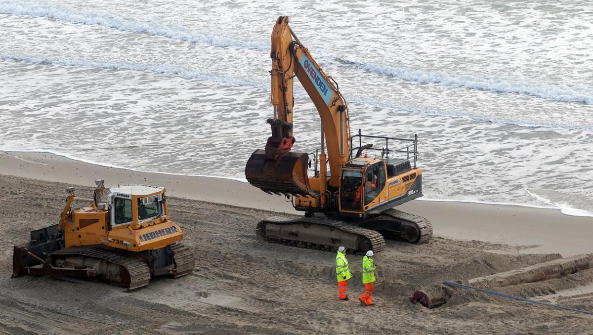 The 700m pipe used to protect Poole's beaches from coastal erosion after the winter storms is removed from Canford Cliffs. Photos by Sally Adams. 