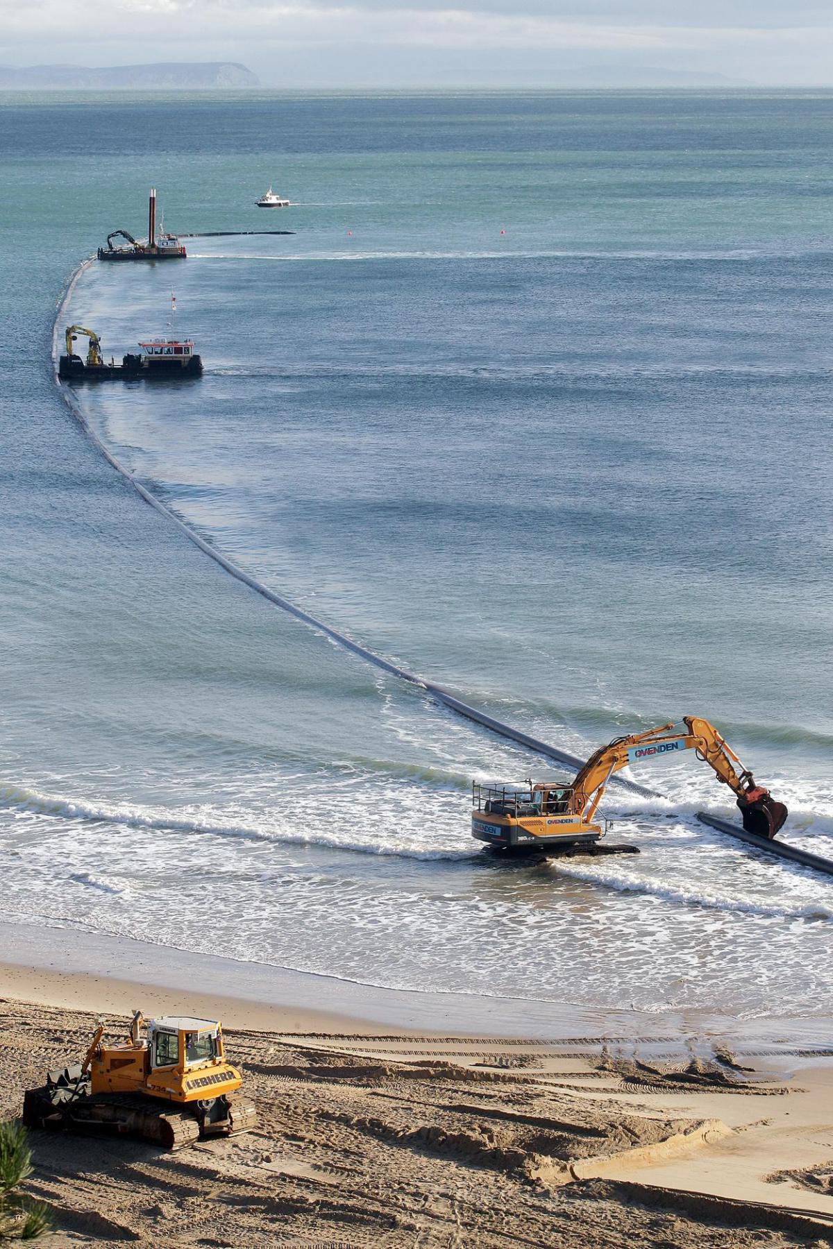 The 700m pipe used to protect Poole's beaches from coastal erosion after the winter storms is removed from Canford Cliffs. Photos by Sally Adams. 